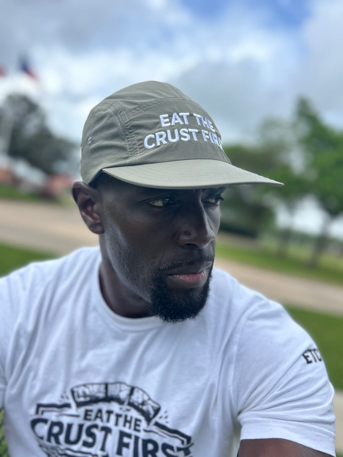Joshua wearing an olive Eat The Crust First performance hat and white ETCF shirt outdoors